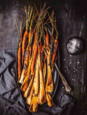 These maple glazed carrots with bourbon are made by roasting carrots and parsnips, if desired, and finishing them with a sweet and buttery bourbon, maple syrup, and apple cider vinegar glaze